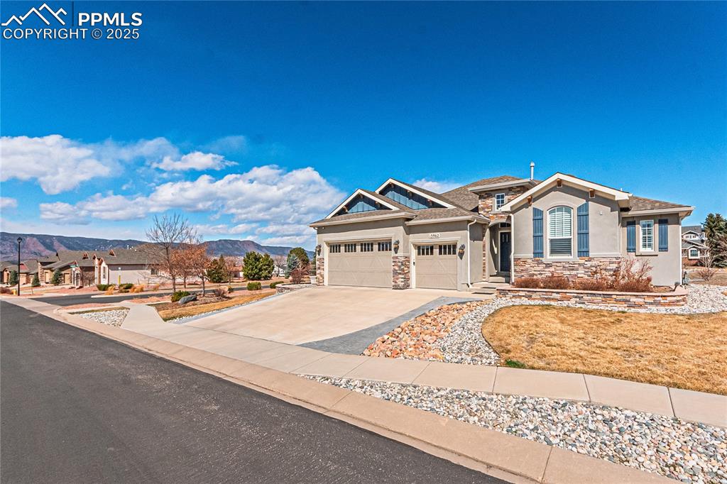 Image 2 of 36: View of front facade featuring a mountain view, stucco siding, a garage, st