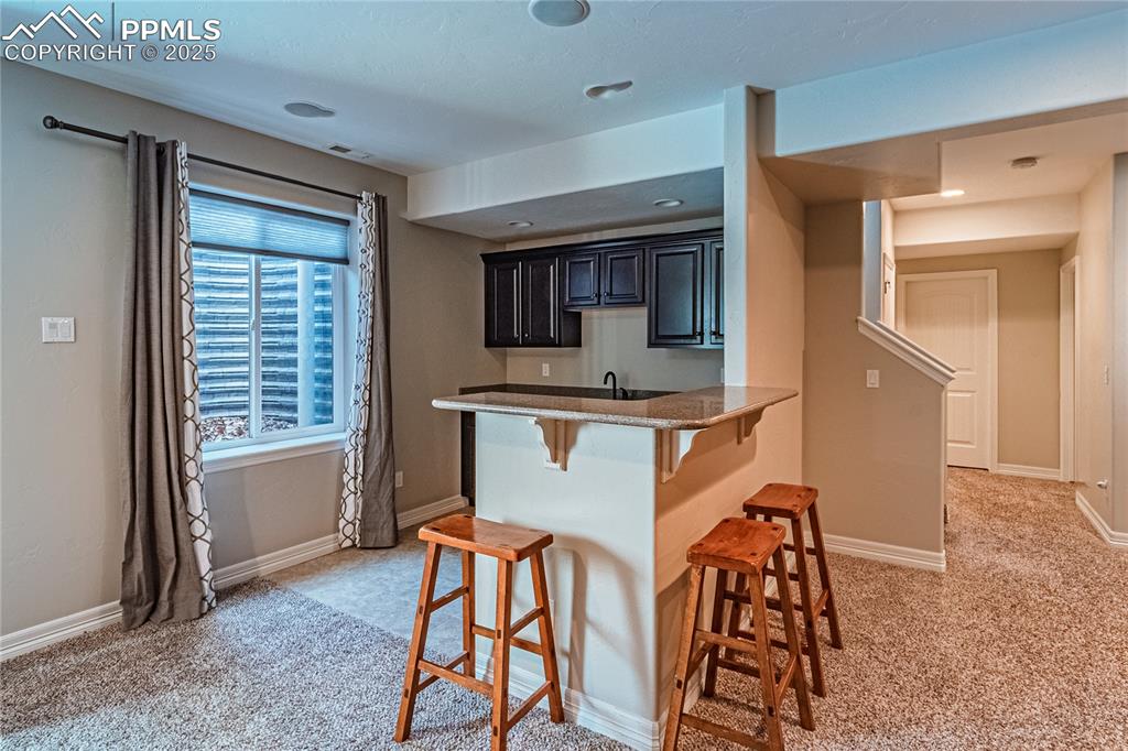 Image 21 of 36: Kitchen featuring a kitchen bar, visible vents, a peninsula, baseboards, an