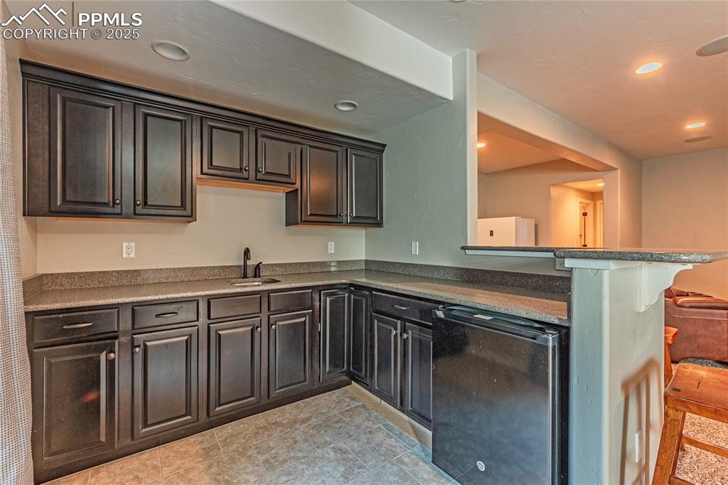 Image 22 of 36: Kitchen featuring a breakfast bar, recessed lighting, a peninsula, refriger
