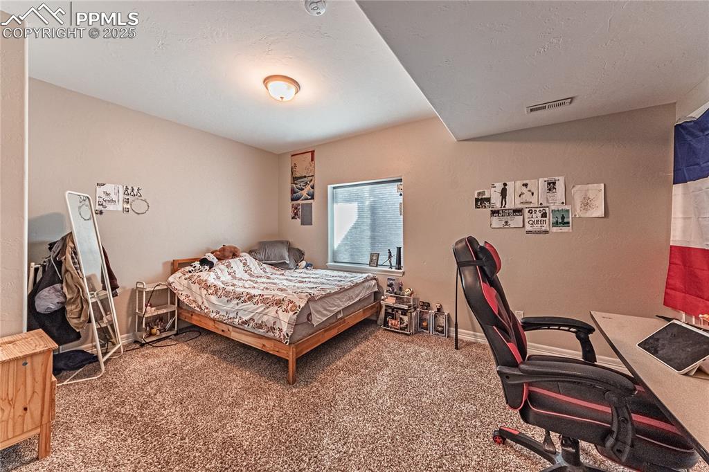 Image 27 of 36: Bedroom featuring carpet flooring, baseboards, visible vents, and a texture