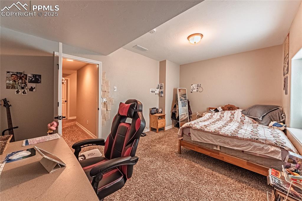 Image 28 of 36: Carpeted bedroom with baseboards and visible vents