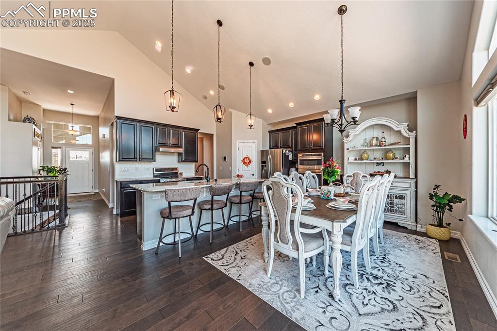 Image 3 of 36: Dining room featuring a wealth of natural light, high vaulted ceiling, dark