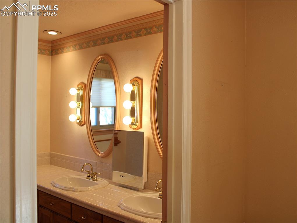 Image 26 of 48: Primary Bathroom with double vanity and crown molding