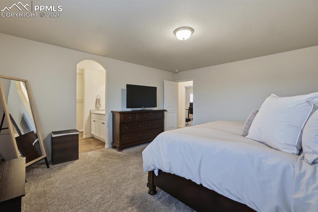 Image 21 of 38: archway leads to the primary bathroom