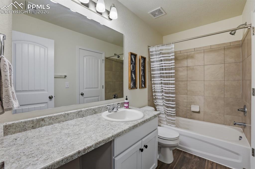 Image 30 of 38: oversized vanity, tub/shower combo with tile surround