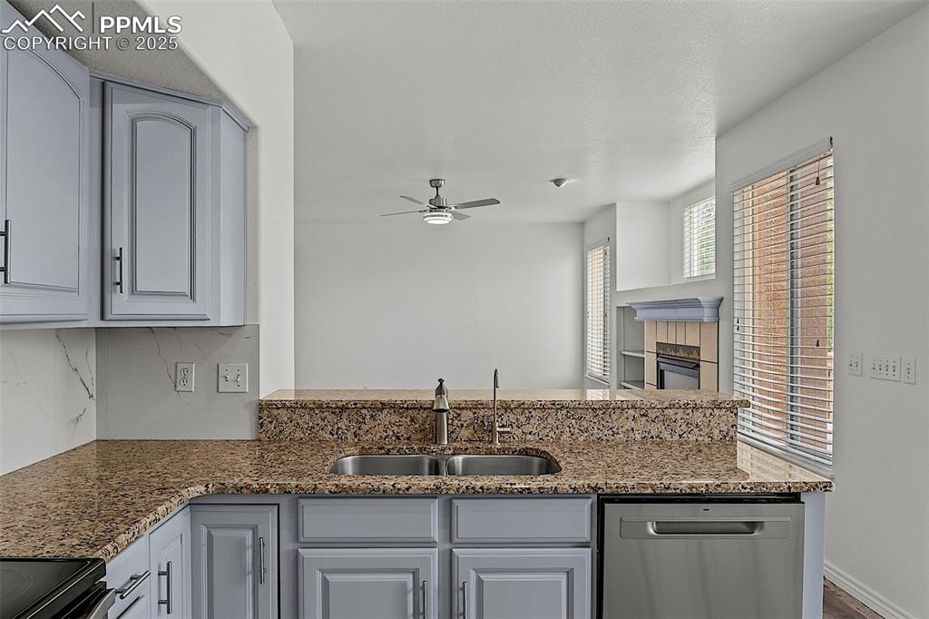 Image 21 of 48: Kitchen with dishwasher, a sink, ceiling fan, decorative backsplash, and st