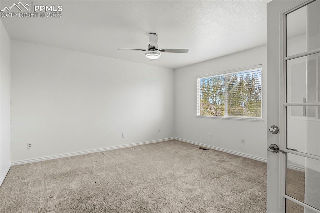 Image 23 of 48: Unfurnished bedroom with carpet floors, baseboards, and ceiling fan