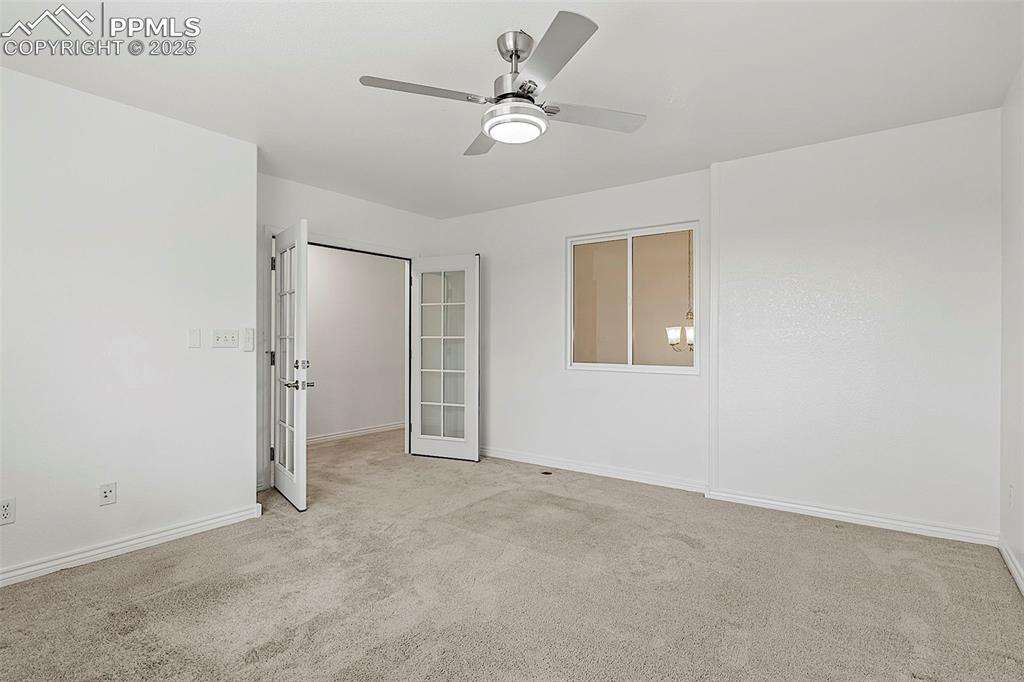 Image 24 of 48: Unfurnished bedroom featuring carpet floors, french doors, baseboards, and 