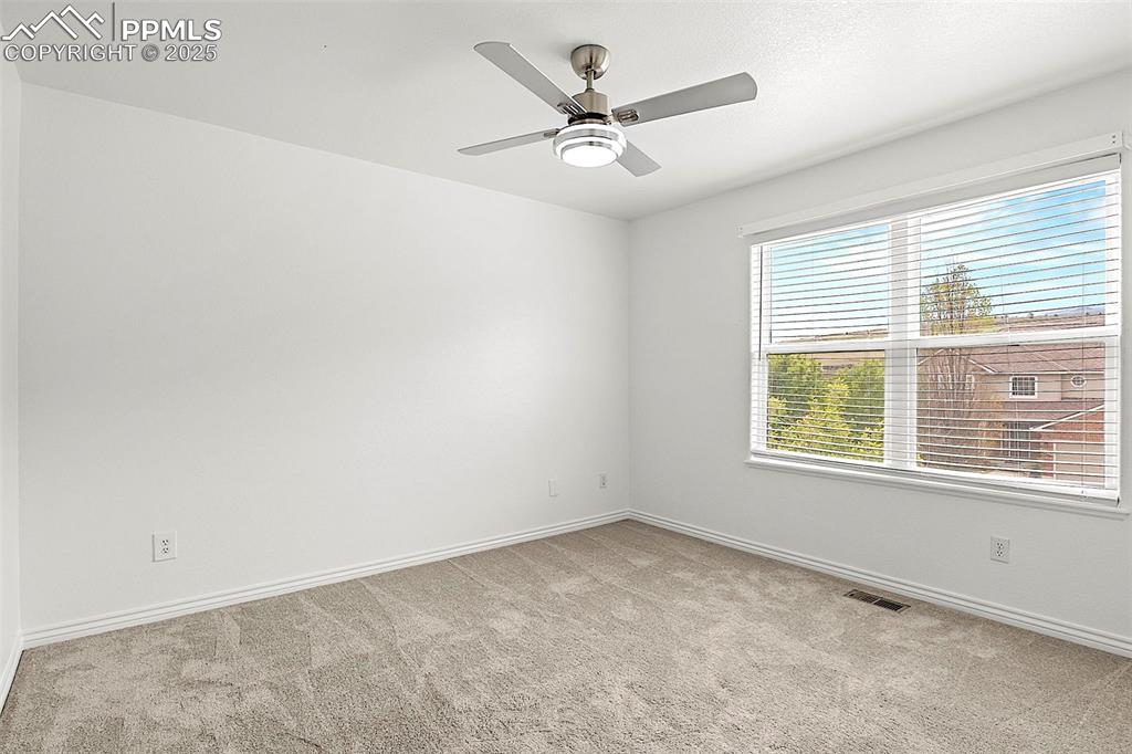 Image 33 of 48: Spare room with carpet, baseboards, and a ceiling fan