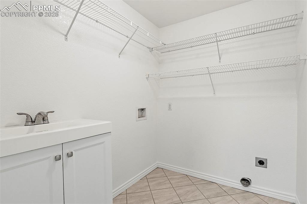 Image 35 of 48: Clothes washing area with hookup for an electric dryer, baseboards, washer 