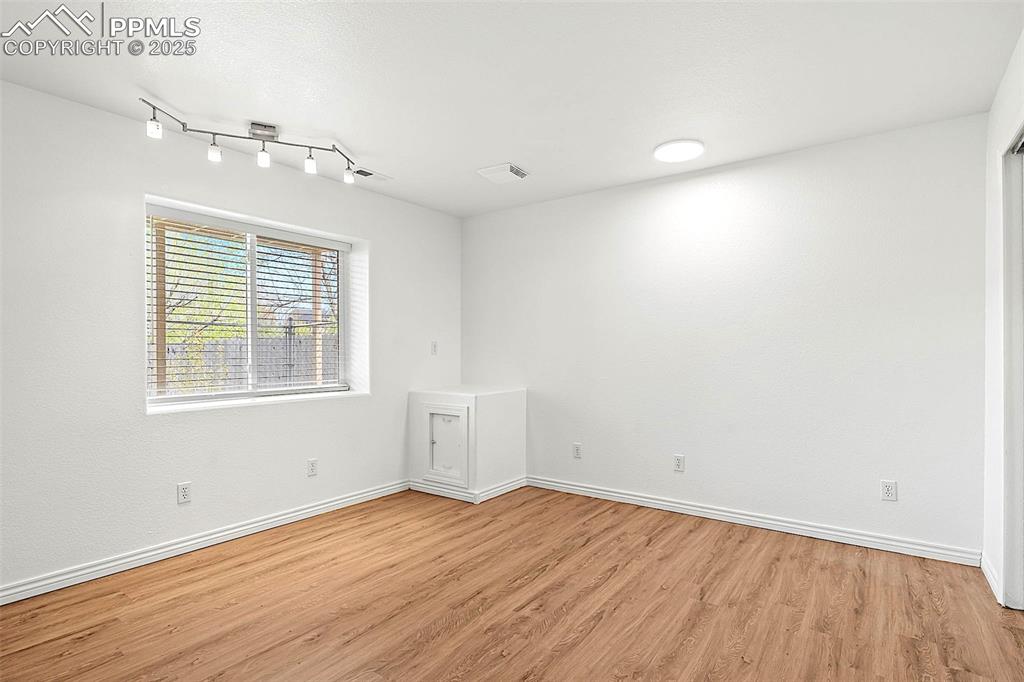 Image 38 of 48: Empty room with light wood-style flooring and baseboards