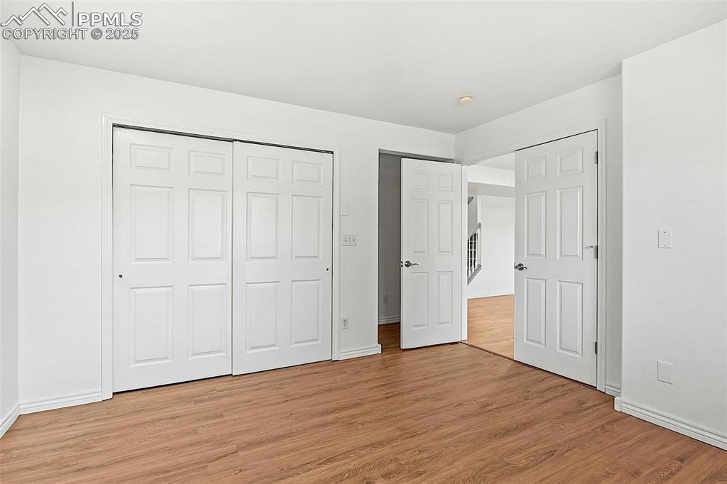 Image 39 of 48: Unfurnished bedroom with light wood-style floors, baseboards, and a closet