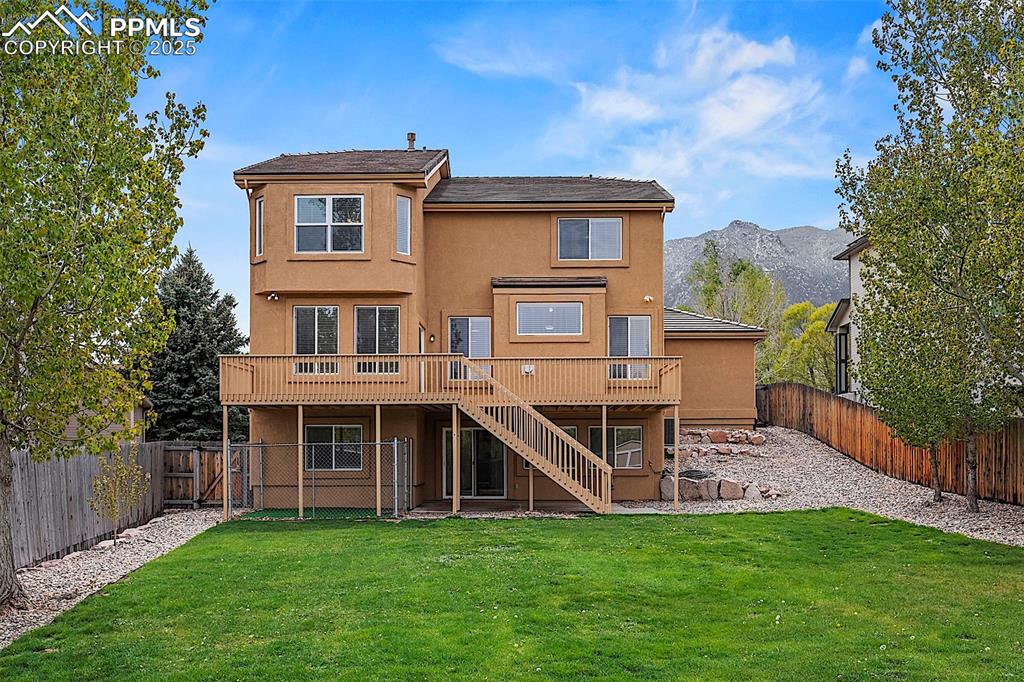 Image 4 of 48: Rear view of property featuring stairs, a deck with mountain view, and stuc