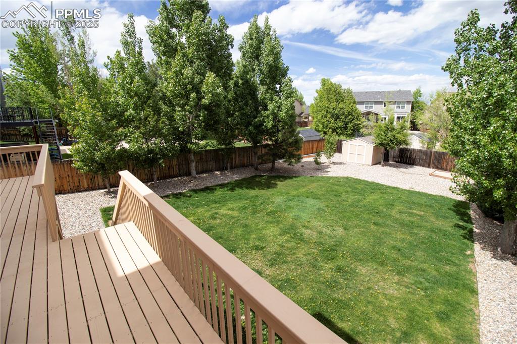 Image 44 of 48: View of yard featuring a wooden deck, a storage shed, and an outdoor struct
