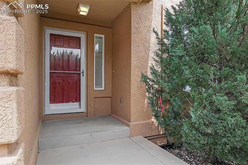 Image 7 of 48: Entrance to property featuring stucco siding