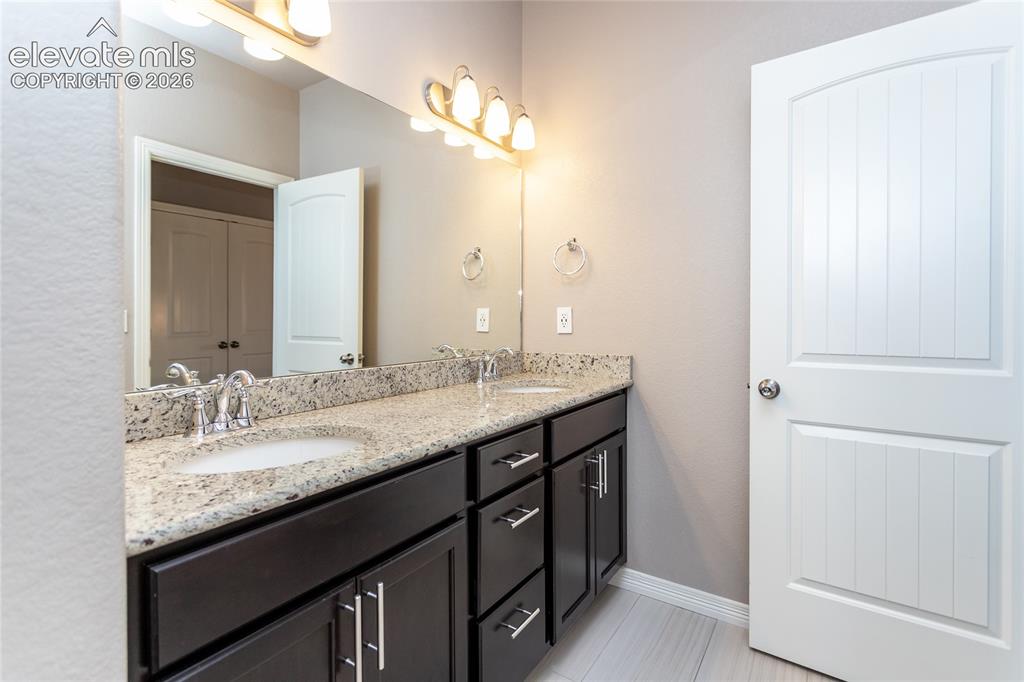 Image 34 of 45: Upstairs bathroom with double sinks and separated shower/tub and toilet