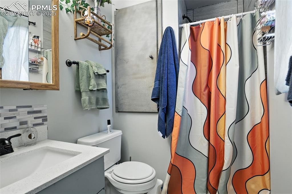 Image 19 of 35: Full bath featuring tasteful backsplash, vanity, and curtained shower