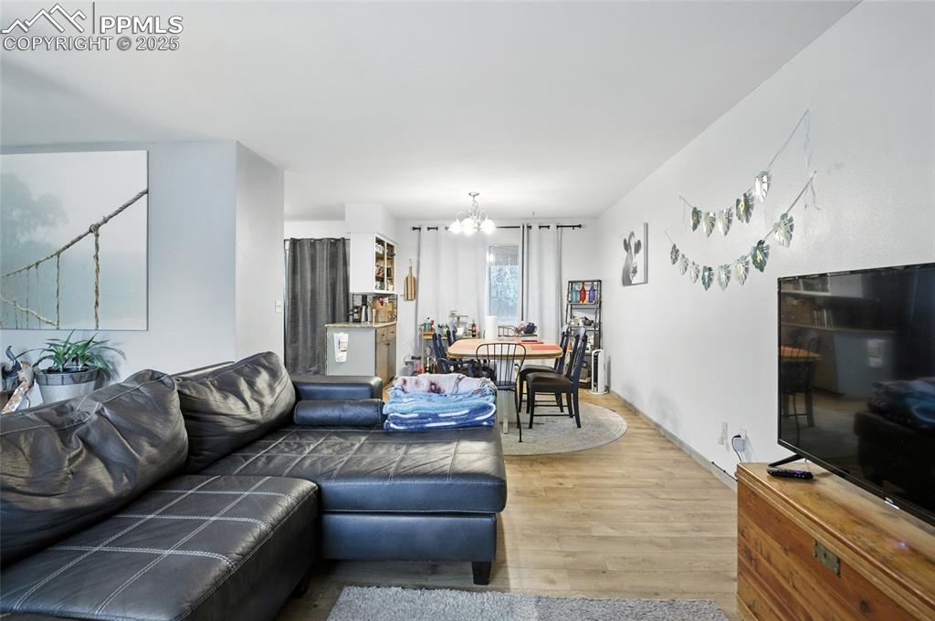 Image 9 of 35: Living room featuring wood finished floors and a chandelier