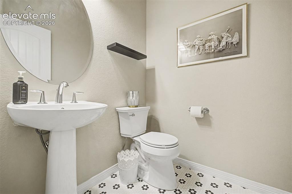 Image 10 of 46: Main-level powder bath offers a touch of personality with custom flooring a