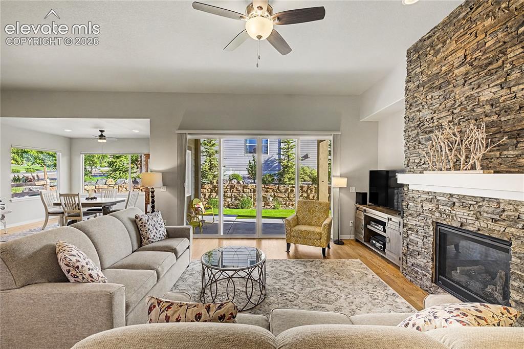 Image 12 of 46: Warm and inviting family room features a cozy fireplace, abundant natural l