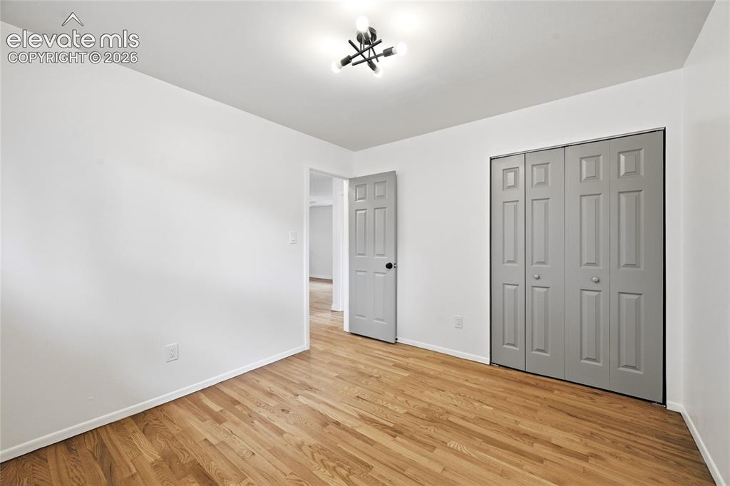 Image 16 of 30: Hardwood flooring throughout, featuring a modern semi-flush mount light fix
