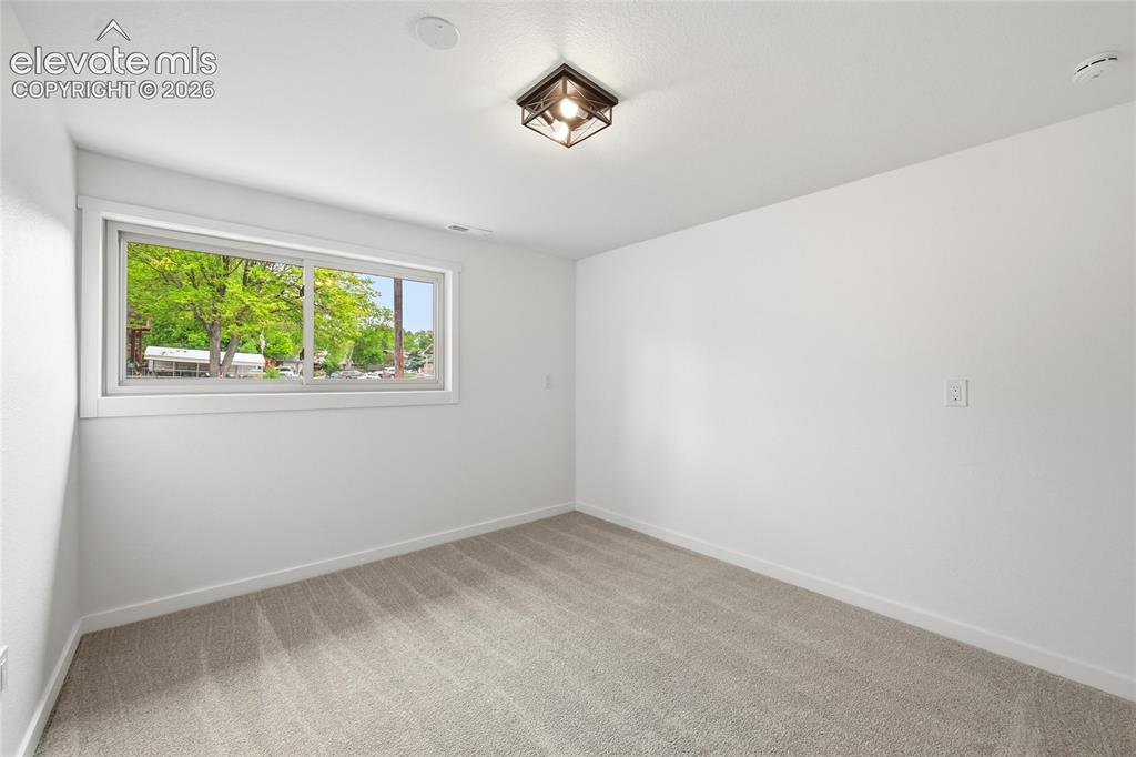 Image 21 of 30: Room featuring neutral tone carpeting and a broad window with white trim