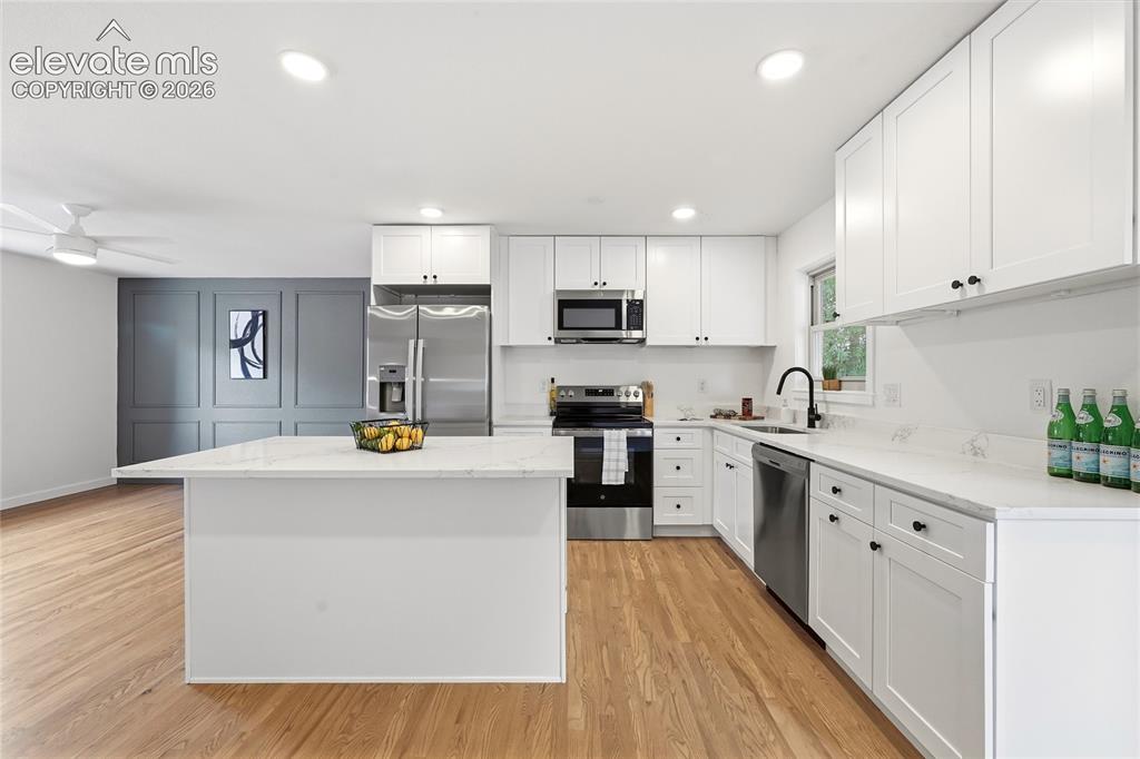 Image 8 of 30: Modern kitchen featuring white shaker cabinetry, stainless steel appliances