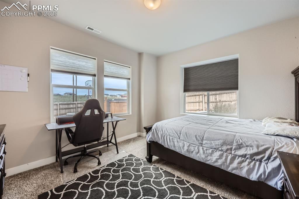 Image 21 of 27: Carpeted bedroom with baseboards and an office area