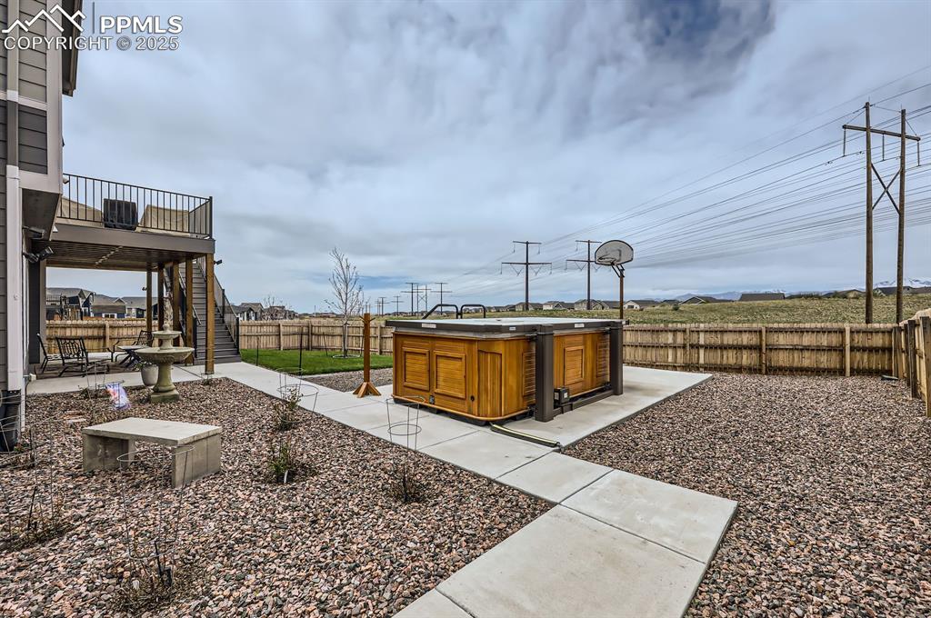 Image 27 of 27: Fenced backyard with stairway, a deck, a patio area, Basketball court and s