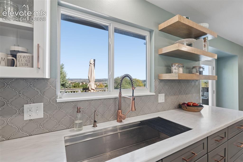 Image 10 of 49: Kitchen featuring a stainless steel farmhouse-style sink, copper-toned goos