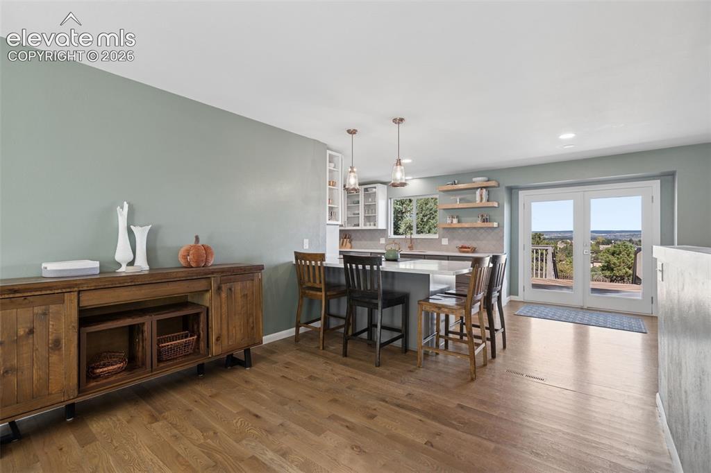 Image 12 of 49: Kitchen featuring a central island with quartz countertops, wood-finish flo