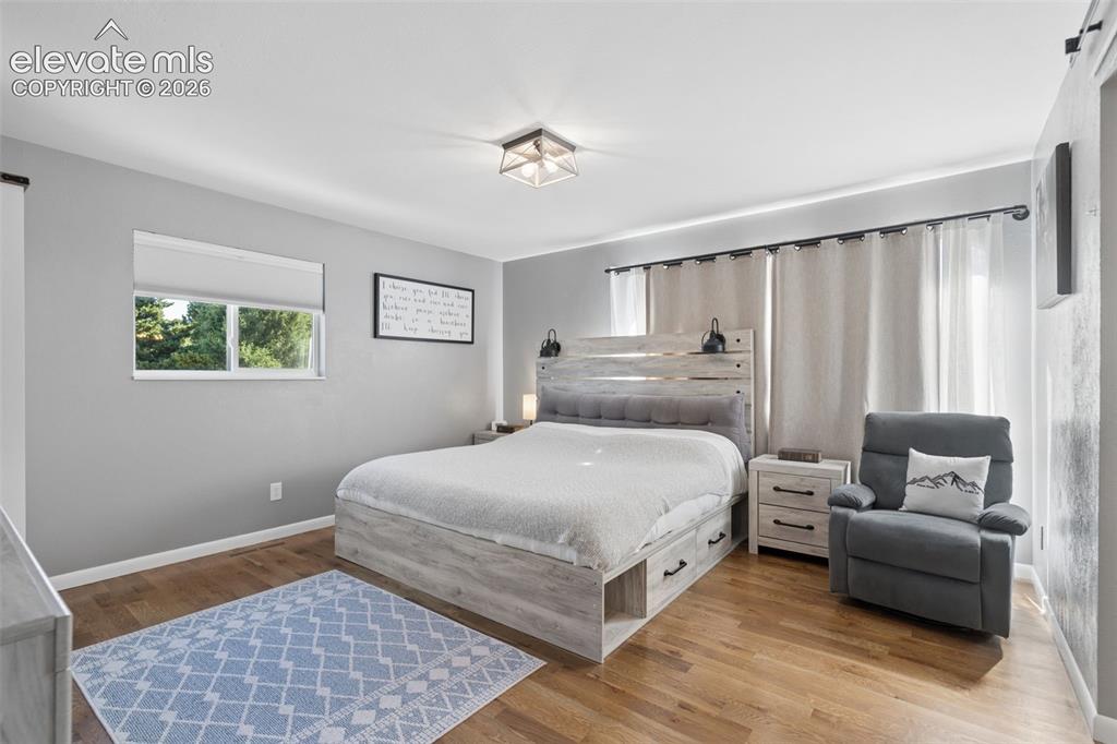 Image 14 of 49: Neutral-toned walls paired with wood-finish flooring, a flush-mount geometr
