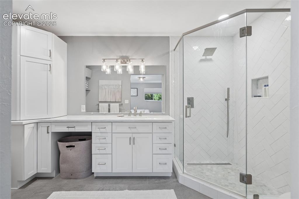 Image 16 of 49: White shaker-style cabinetry with extensive counter space, large-format mir