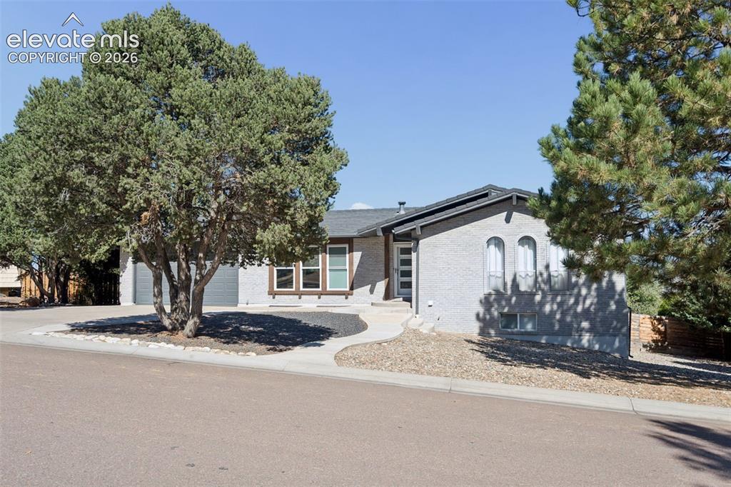 Image 2 of 49: Exterior featuring textured gray masonry, arched windows, covered entryway,