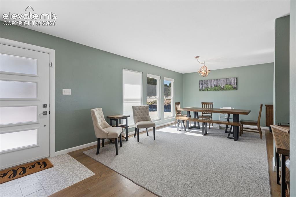 Image 21 of 49: Front entry featuring a four-panel door with frosted glass inserts, wood-fi