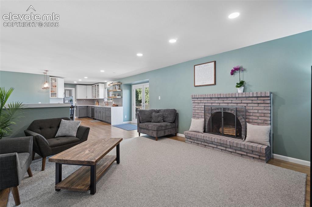 Image 26 of 49: Brick fireplace featuring a raised hearth, recessed lighting, double glass 