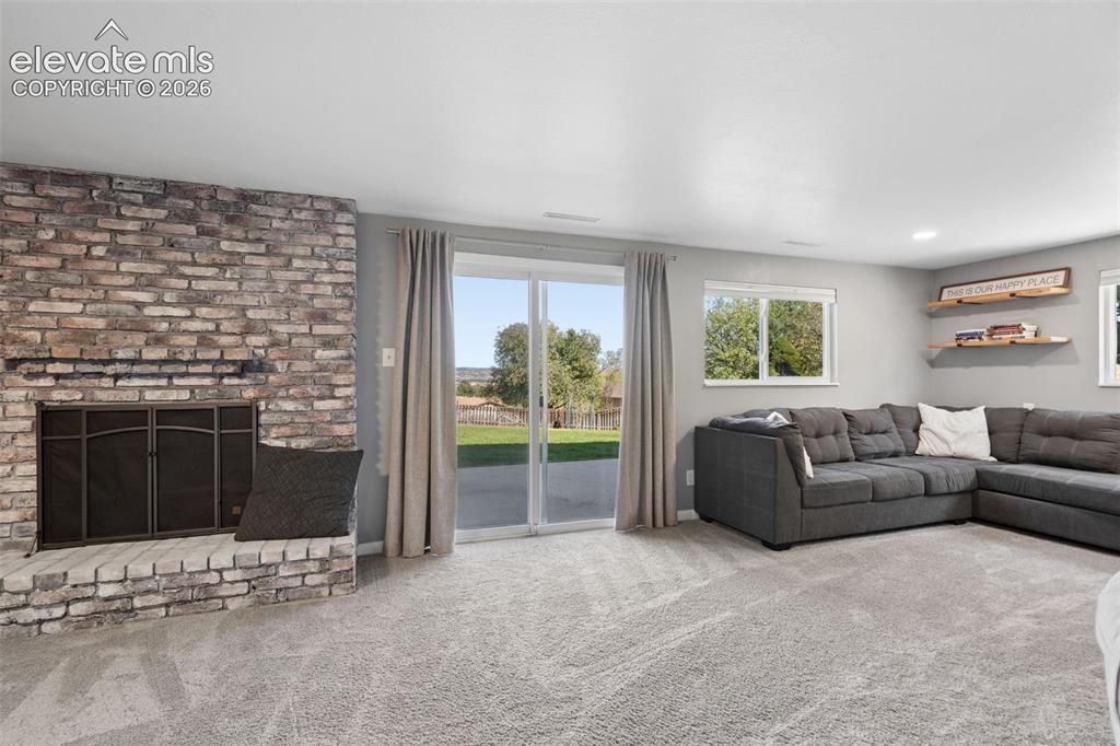 Image 33 of 49: Basement Walk Out Full-height brick masonry fireplace with a raised hearth,