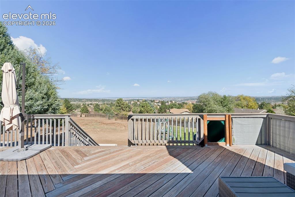 Image 43 of 49: Elevated wood deck featuring vertical baluster railings, herringbone-patter