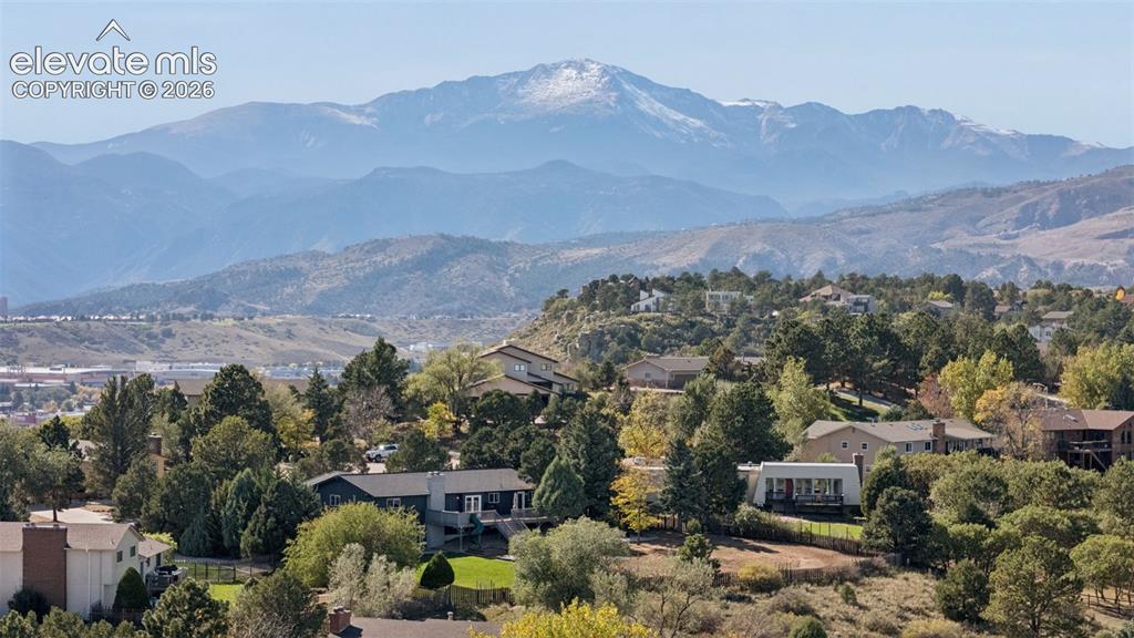 Image 49 of 49: Elevated aerial perspective featuring a mountain backdrop, mature trees, an