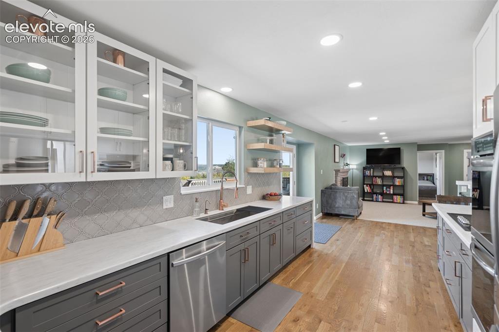 Image 7 of 49: Kitchen featuring charcoal-toned lower cabinetry, white upper cabinets with