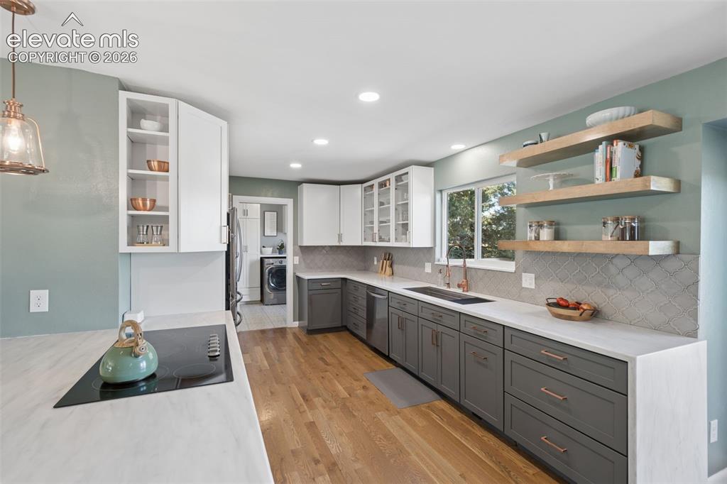 Image 9 of 49: Kitchen featuring wood-finish flooring, two-tone cabinetry with contrasting