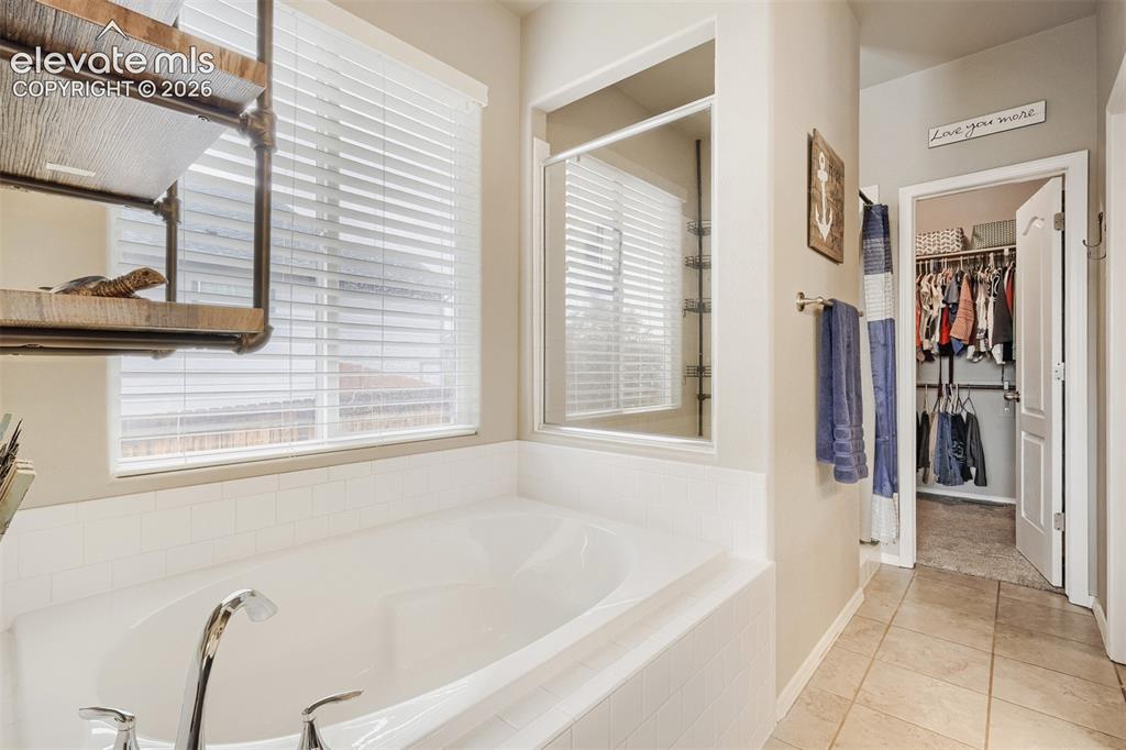 Image 13 of 31: Spacious bathroom featuring a dual vanity with dark wood-finish cabinetry,