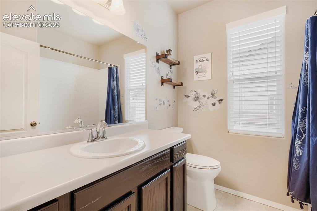 Image 16 of 31: Main level third bedroom with light-toned carpet flooring complements the n