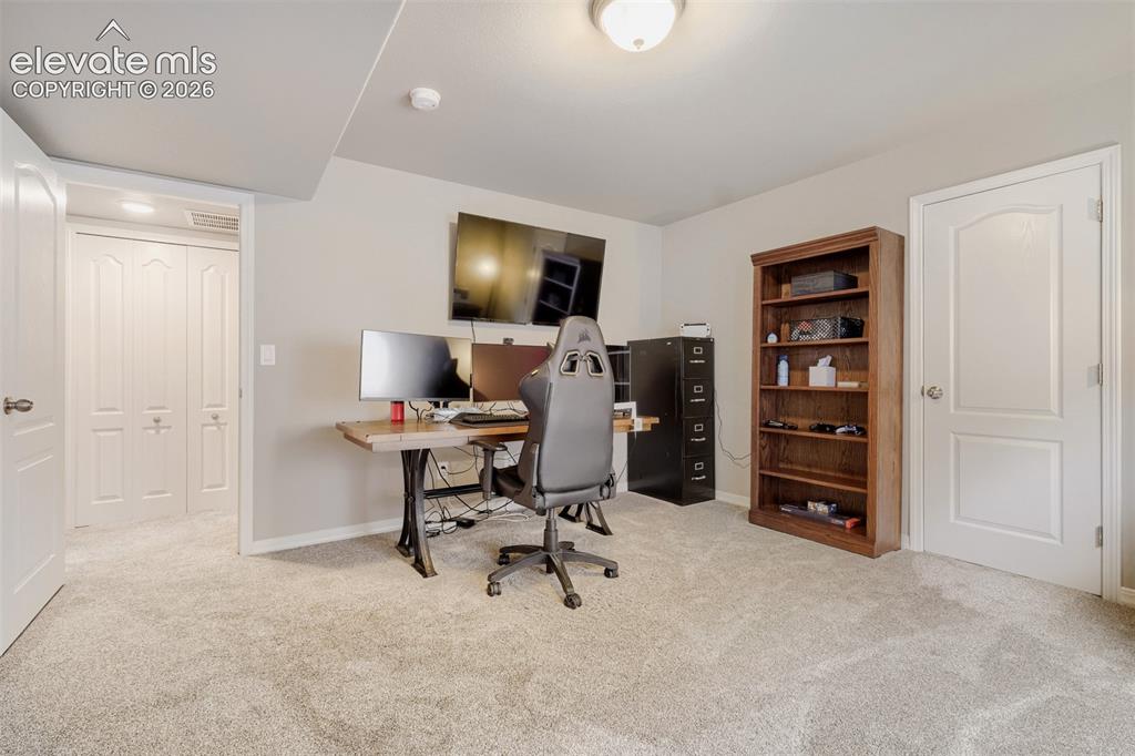 Image 24 of 31: Spacious lower level featuring plush carpeting, recessed lighting, and a vi