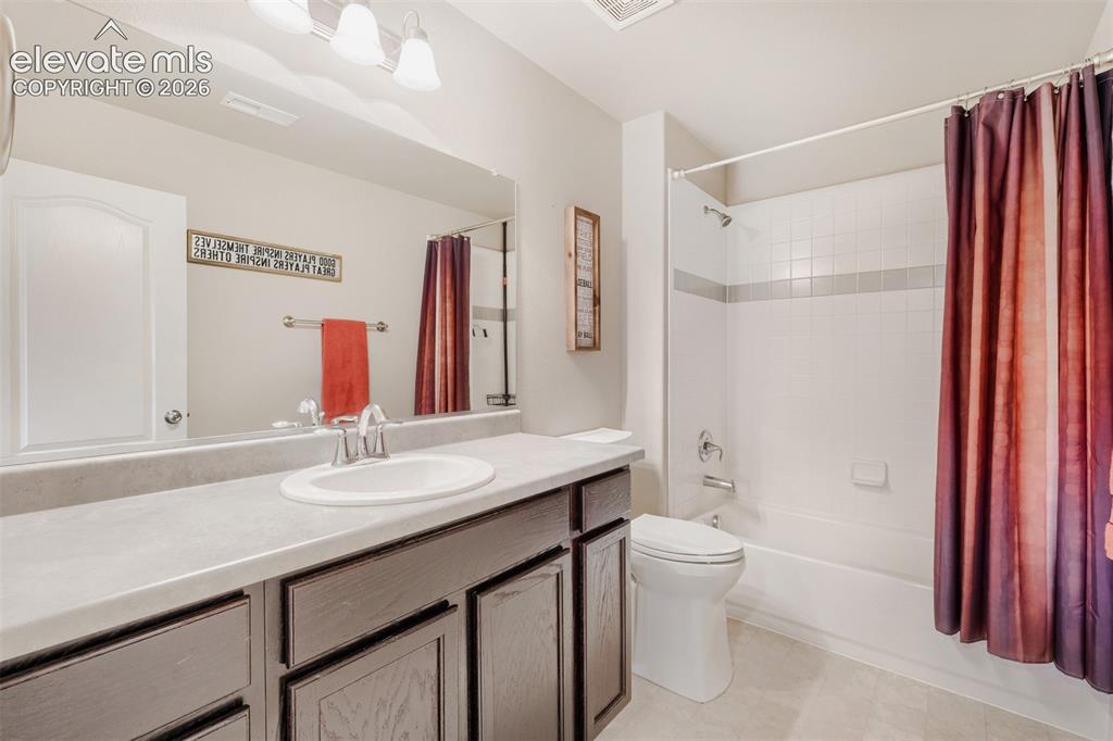 Image 26 of 31: The basement’s fifth bedroom offers light-colored walls, a window with blin