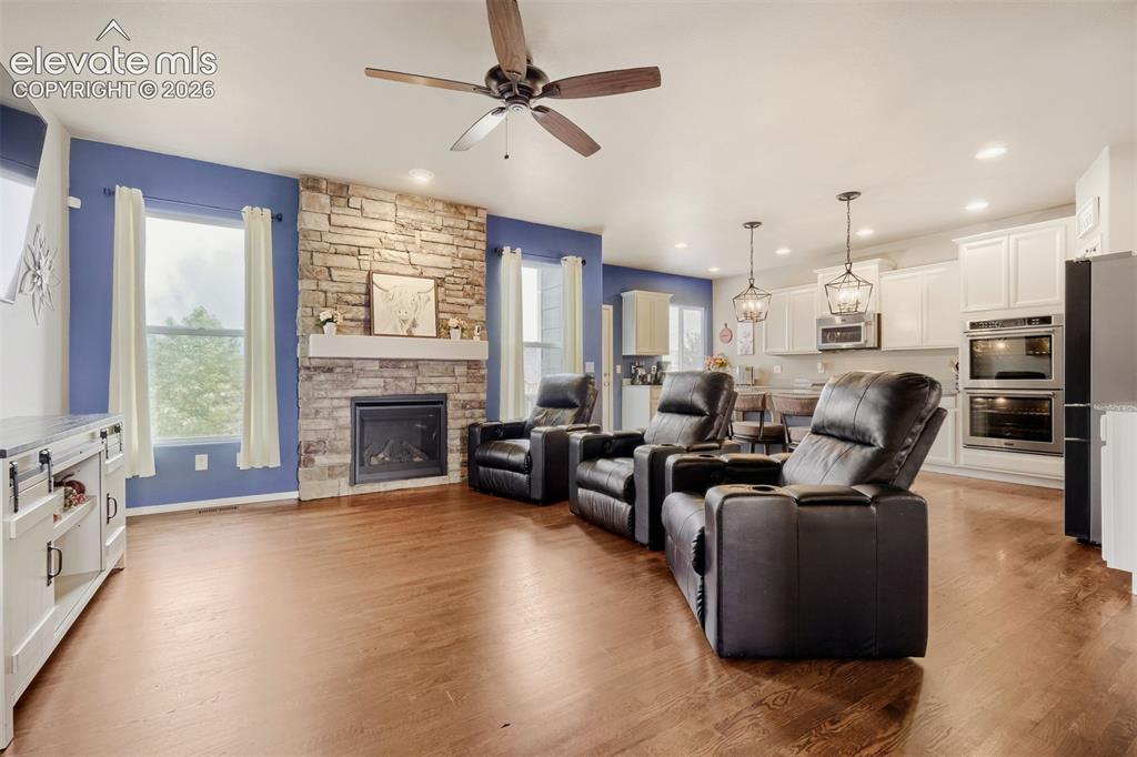 Image 4 of 31: Entryway featuring rich wood-finish flooring and wrought iron balusters- we