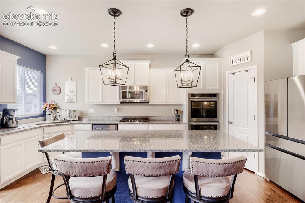 Image 8 of 31: Spacious cooks delight kitchen featuring an island with granite countertops
