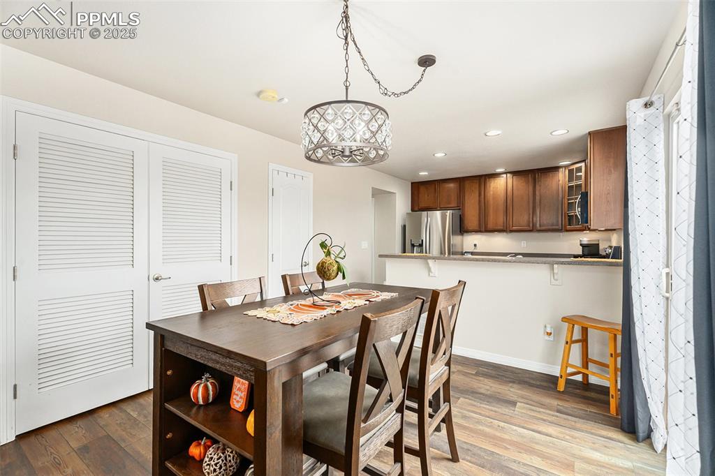 Image 11 of 30: Dining area with recessed lighting, wood finished floors, and a chandelier