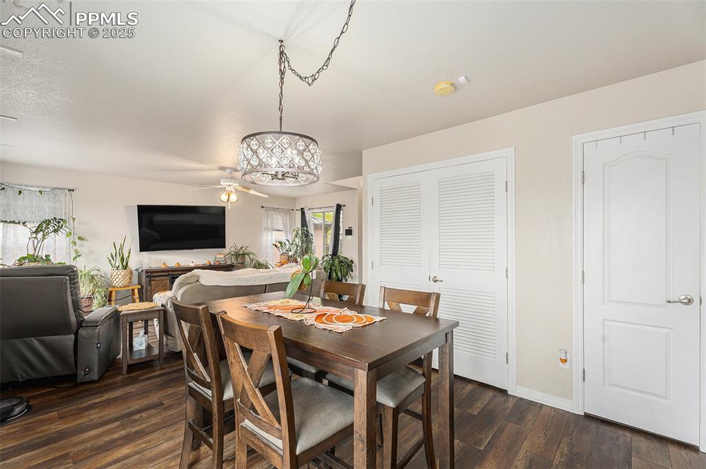 Image 12 of 30: Dining space featuring dark wood-style floors and baseboards