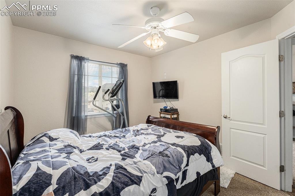 Image 23 of 30: Carpeted bedroom with a ceiling fan
